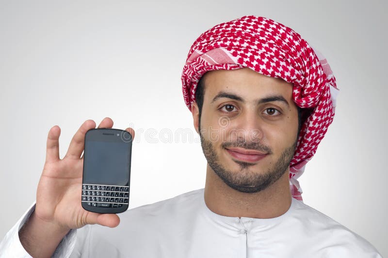 Retrato de um homem de negócio árabe que guarda um telefone para a apresentação imagens de stock royalty free Retrato de um homem de negócio árabe que guarda um telefone para a apresentação imagens de stock royalty free