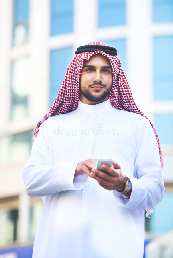 Retrato de um homem árabe considerável que usa um telefone esperto