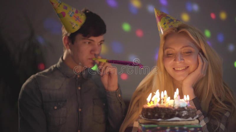 Retrato de um indivíduo considerável e de uma menina que comemoram seu aniversário que senta-se em uma tabela com um bolo Velas d