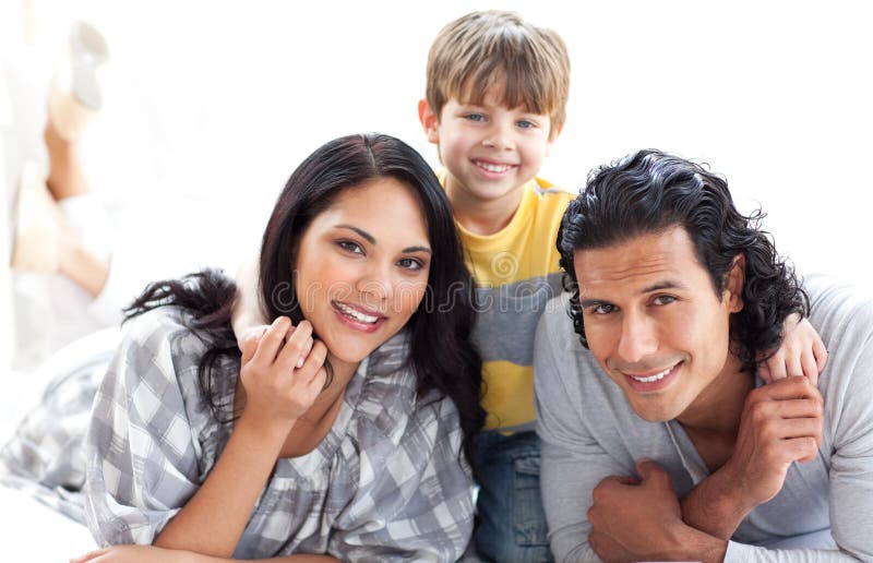 Retrato de uma família loving que encontra-se no assoalho imagens de stock Retrato de uma família loving que encontra-se no assoalho imagens de stock