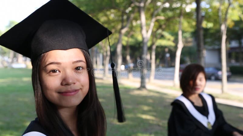 Retrato de uma feliz e sorridente estudante asiática no dia da graduação