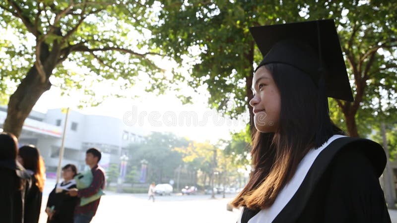 Retrato de uma feliz e sorridente estudante asiática no dia da graduação