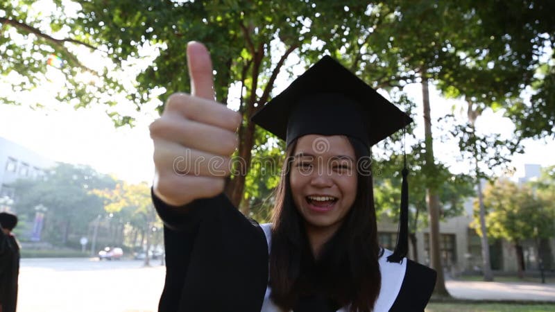 Retrato de uma feliz e sorridente estudante asiática no dia da graduação