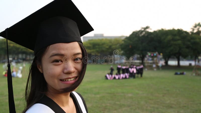 Retrato de uma feliz e sorridente estudante asiática no dia da graduação