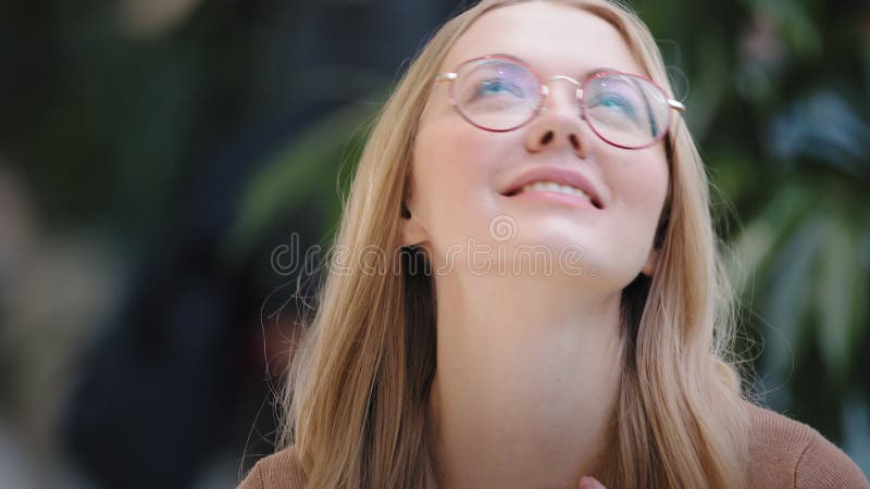 Retrato de uma garota caucasiana loira bem-sucedida mulher sortuda em óculos olha a tela do celular ganha mensagem online