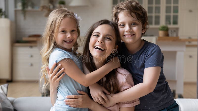 Retrato de uma jovem e feliz abraçando-se com crianças pequenas