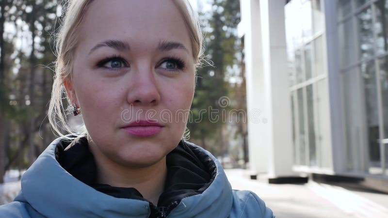 Retrato de uma loura choradora 4k. lágrimas enrolam o rosto de uma jovem. uma mulher triste limpa seus olhos cheios de