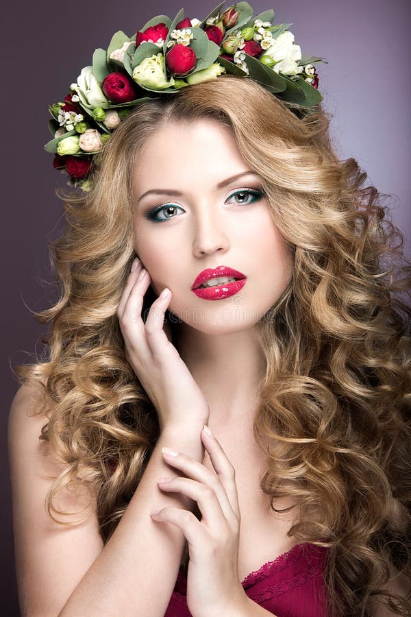Retrato de uma menina loura bonita com ondas e da grinalda de flores roxas em sua cabeça Face da beleza fotos de stock Retrato de uma menina loura bonita com ondas e da grinalda de flores roxas em sua cabeça Face da beleza fotos de stock