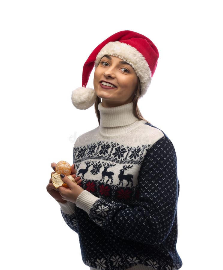 Retrato de uma menina no tampão de Santa com tangerina à disposição fotografia de stock Retrato de uma menina no tampão de Santa com tangerina à disposição fotografia de stock