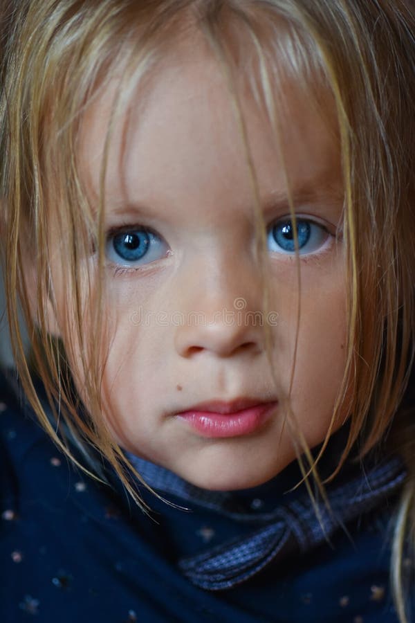 Retrato de uma menina romântica triste com olhos azuis grandes de Europa Oriental, close-up, fundo escuro foto de stock royalty free Retrato de uma menina romântica triste com olhos azuis grandes de Europa Oriental, close-up, fundo escuro foto de stock royalty free