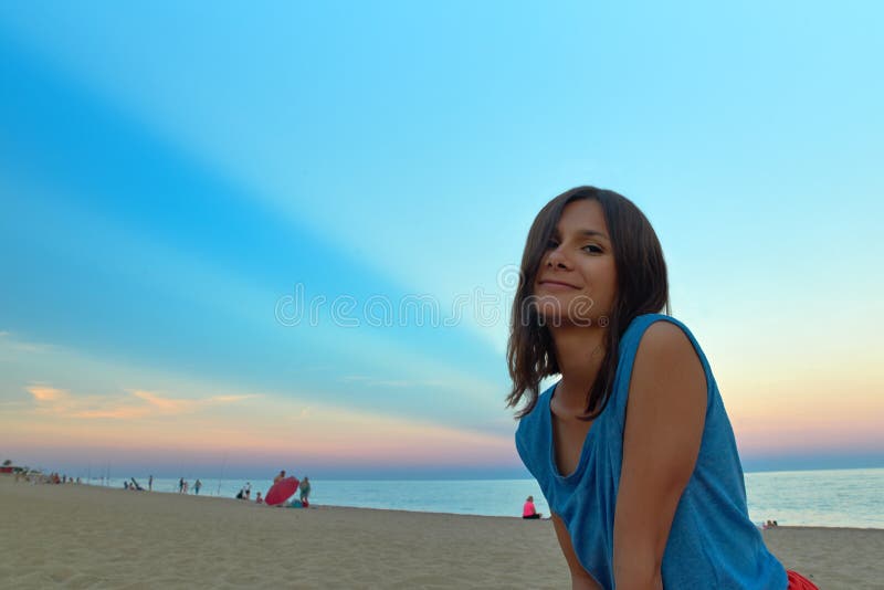 Retrato de uma mulher de cabelos compridos nova no por do sol na praia Co imagens de stock Retrato de uma mulher de cabelos compridos nova no por do sol na praia Co imagens de stock