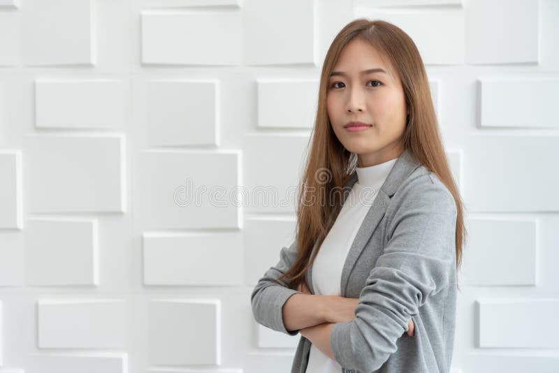 Retrato de uma mulher de negócio asiática segura que está sobre o branco foto de stock Retrato de uma mulher de negócio asiática segura que está sobre o branco foto de stock