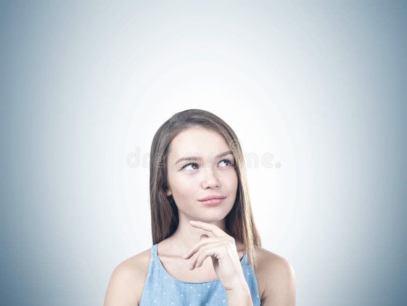Retrato de uma mulher pensativa nova, cinzento imagem de stock Retrato de uma mulher pensativa nova, cinzento imagem de stock