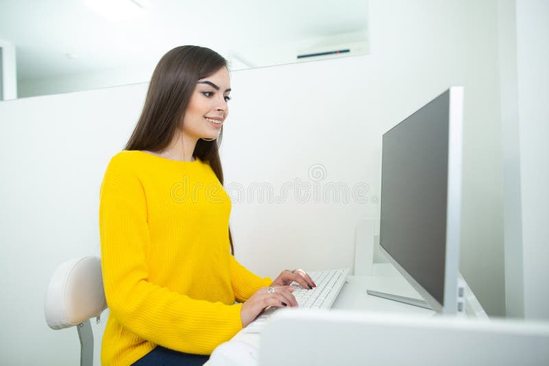 Retrato de uma mulher de sorriso bonita que trabalha em sua mesa em um ambiente do escritório fotos de stock royalty free Retrato de uma mulher de sorriso bonita que trabalha em sua mesa em um ambiente do escritório fotos de stock royalty free