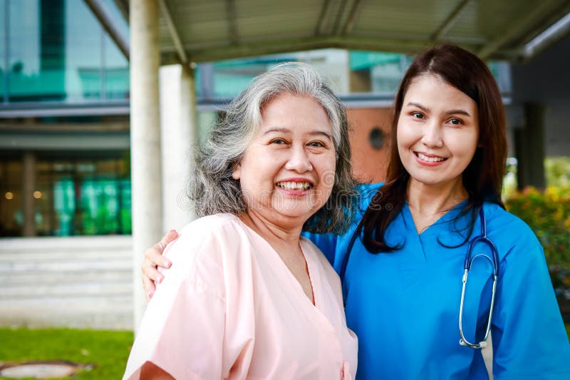 Portrait of an elderly female patient and a surgeon, both smiling brightly, standing outside a building. Medical services in hospitals. health insurance. Portrait of an elderly female patient and a surgeon, both smiling brightly, standing outside a building. Medical services in hospitals. health insurance