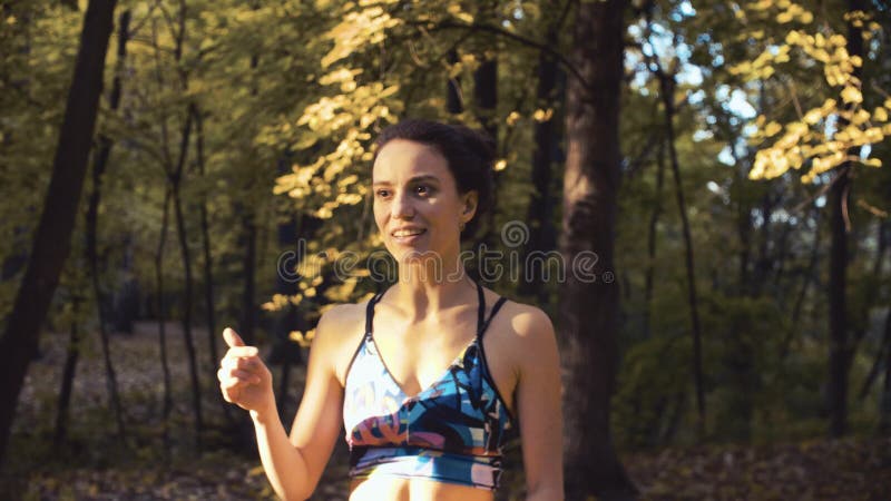 Retrato de uma posição da jovem mulher na floresta