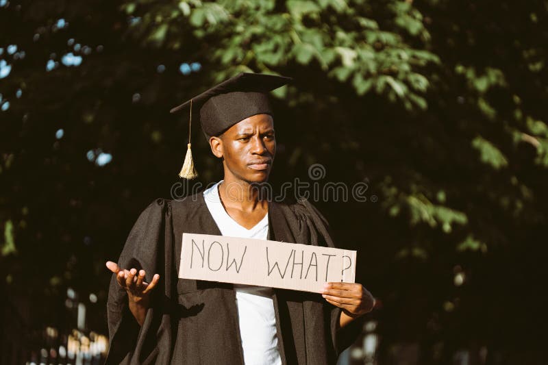 Retrato de un desempleado afroamericano parado con cartón en la calle buscando trabajo y pensando en