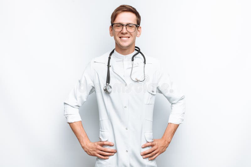 Retrato de un doctor joven en un fondo blanco, interno en el estudio, con un estetoscopio en el cuello fotos de archivo Retrato de un doctor joven en un fondo blanco, interno en el estudio, con un estetoscopio en el cuello fotos de archivo
