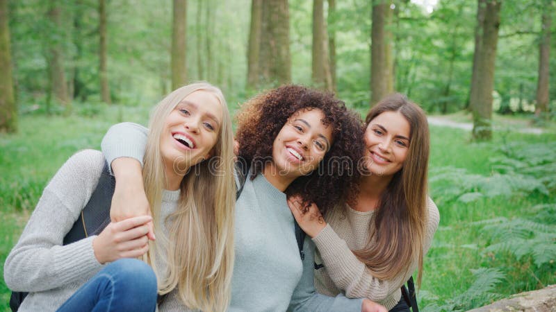 Retrato De Un Grupo Multicultural Sonriente De Amigas Caminando Por Los Bosques En El Distrito De Los Lagos Del Reino Unido foto de archivo