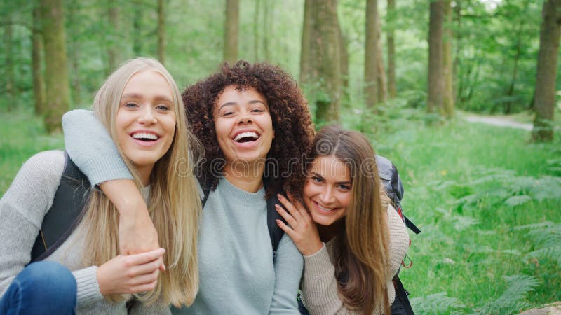 Retrato De Un Grupo Multicultural Sonriente De Amigas Caminando Por Los Bosques En El Distrito De Los Lagos Del Reino Unido imagen de archivo