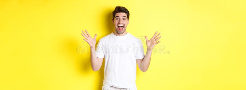 Retrato de un hombre emocionado y sorprendido reaccionando a la gran oferta de promoción gritando de alegría y triunfando sobre el imagenes de archivo