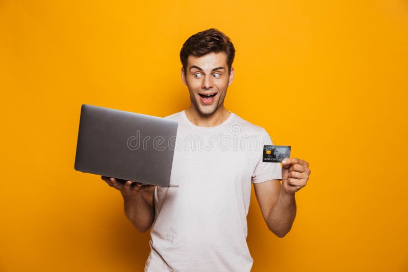 Retrato de un hombre joven alegre que sostiene el ordenador portátil imagenes de archivo Retrato de un hombre joven alegre que sostiene el ordenador portátil imagenes de archivo