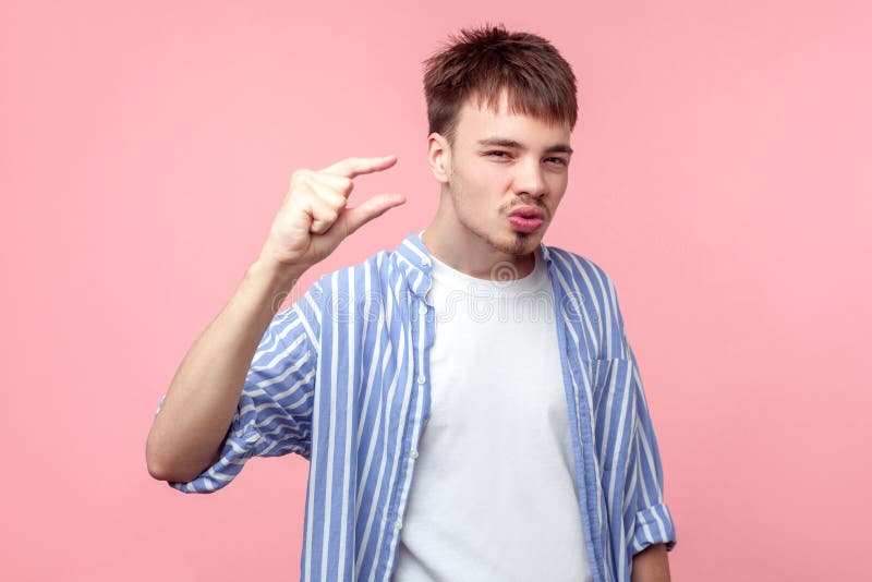 Retrato de un joven descontento de cabello marrón con barba y bigote mostrando un pequeño gesto aislado sobre fondo rosa imagenes de archivo Retrato de un joven descontento de cabello marrón con barba y bigote mostrando un pequeño gesto aislado sobre fondo rosa imagenes de archivo