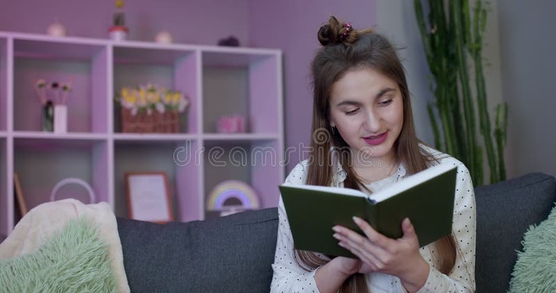 Retrato de un joven estudiante leyendo un libro. bella joven morena leyendo un libro en la cama en casa