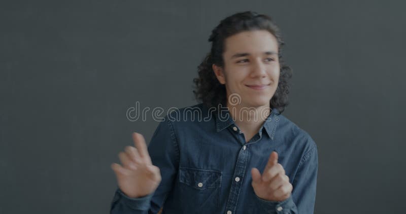 Retrato de un joven hispano bailando escalofriante divirtiéndose sobre el fondo negro almacen de metraje de vídeo