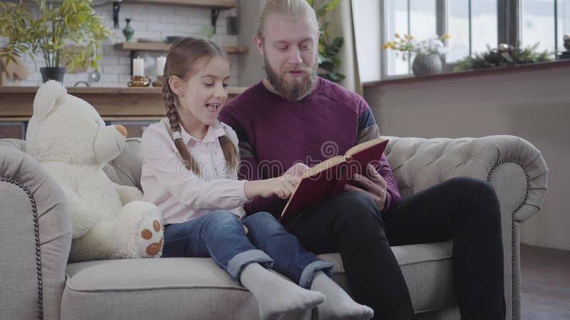 Retrato de un joven padre inteligente leyendo a su adorable hija Niña adolescente interesada escuchando cuidadosamente y