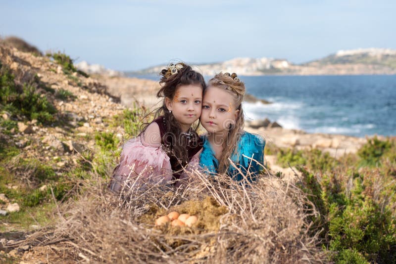 Retrato de un juego religioso de Pascua con dos muchachas en trajes de los pájaros que se sientan cerca de una jerarquía enorme c imagenes de archivo Retrato de un juego religioso de Pascua con dos muchachas en trajes de los pájaros que se sientan cerca de una jerarquía enorme c imagenes de archivo