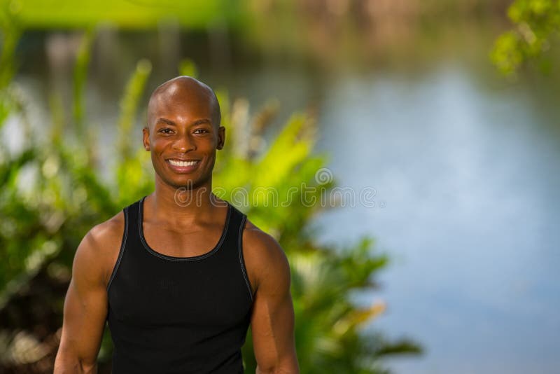 Retrato de un modelo afroamericano sonriente de la aptitud que presenta al aire libre fotografía de archivo