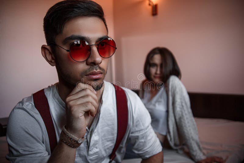Retrato de un morenita triste en gafas de sol al fondo de la cama, una joven morena selectivo imagen de archivo libre de regalías Retrato de un morenita triste en gafas de sol al fondo de la cama, una joven morena selectivo imagen de archivo libre de regalías