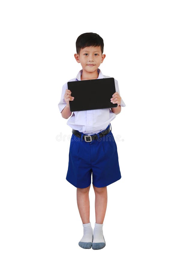 Retrato de un niño asiático de 7 años con uniforme de primaria o primaria que muestra la pantalla en blanco de la tablet fotografía de archivo libre de regalías