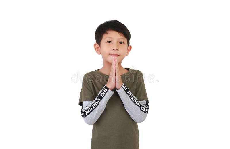 Retrato de un niño asiático sonriente de 7 años de edad que hace señas de oración mientras está aislado en un fondo blanco foto de archivo libre de regalías
