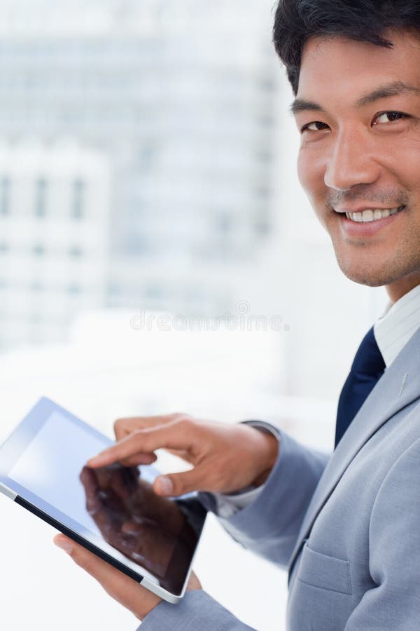 Retrato de un oficinista sonriente que usa un ordenador de la tableta fotos de archivo libres de regalías Retrato de un oficinista sonriente que usa un ordenador de la tableta fotos de archivo libres de regalías