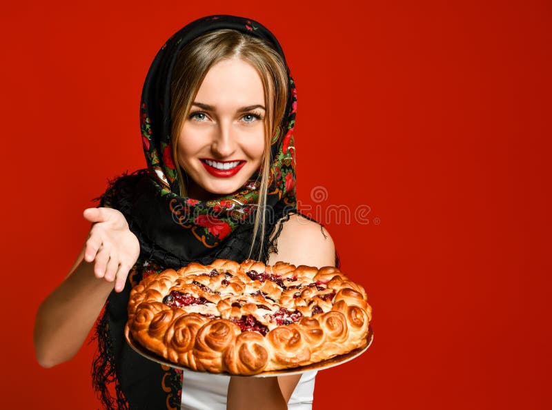 Retrato de un rubio hermoso joven en el pañuelo que sostiene una empanada hecha en casa deliciosa de la baya imagen de archivo Retrato de un rubio hermoso joven en el pañuelo que sostiene una empanada hecha en casa deliciosa de la baya imagen de archivo