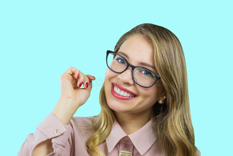 Retrato de un rubio joven atractivo en los vidrios que llevan a cabo su mano a ella que mira la cámara con una sonrisa amplia en imagen de archivo Retrato de un rubio joven atractivo en los vidrios que llevan a cabo su mano a ella que mira la cámara con una sonrisa amplia en imagen de archivo