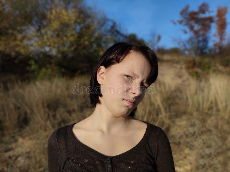 Retrato de una adolescente frunciendo el ceño disgustada al aire libre