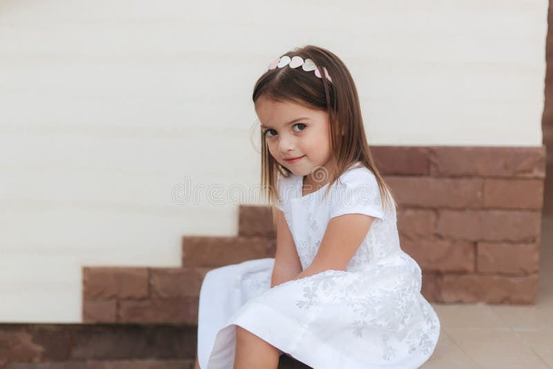 Retrato De Una Bella Niña De Vestido Blanco Sentada En Las Escaleras Por Casa Imagen archivo Imagen de picnic, muchacha: 191148895