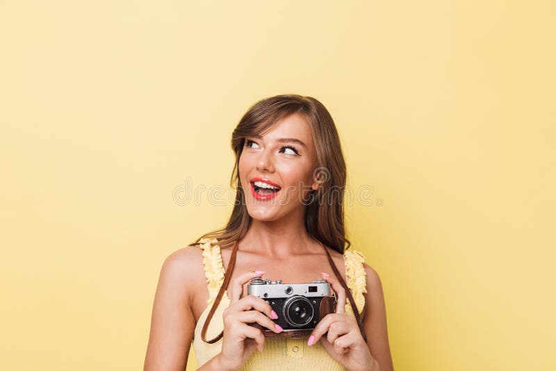 Retrato de una chica joven feliz que sostiene la cámara de la foto fotografía de archivo Retrato de una chica joven feliz que sostiene la cámara de la foto fotografía de archivo
