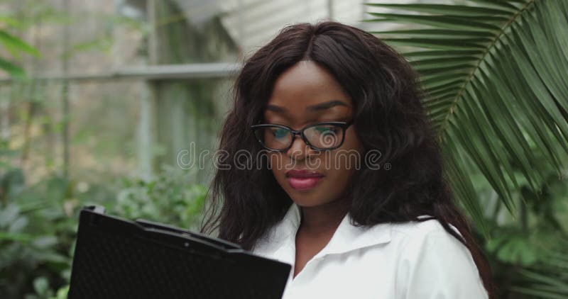 Retrato de una científica analiza los datos y escribe. joven afroamericano en apariencia de asistente de gafas metrajes