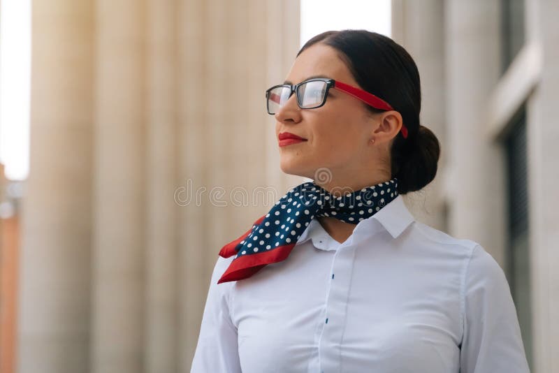 De Una Elegante Camarera Sonriente En Una Blusa De Camisa Con Un Pañuelo Alrededor De Su Cuello. Chica Misteriosa E Imagen de archivo - Imagen de aeropuerto, fondo: