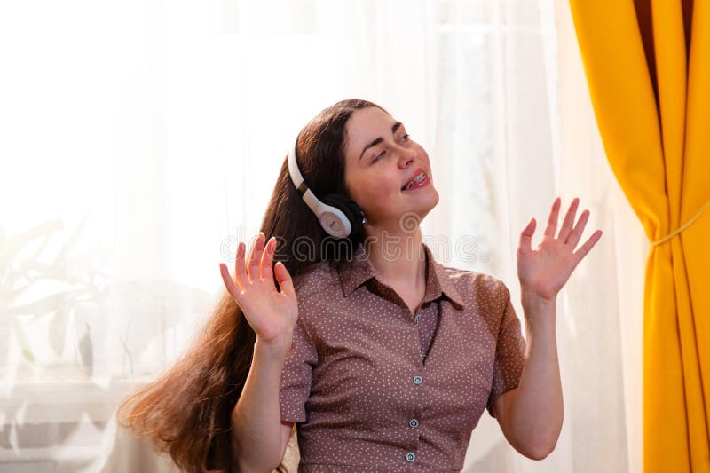 Retrato de una hembra sonriente que deja que la música le guíe en su baile y en sus emociones. Concepto de felicidad y relajación imágenes de archivo libres de regalías