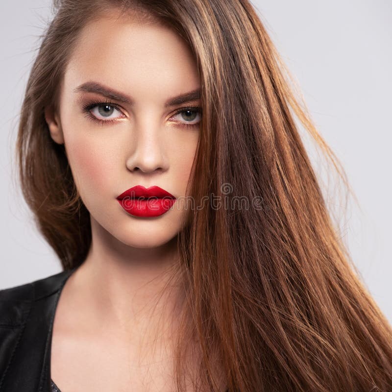 Retrato de una hermosa joven con un maquillaje brillante Hermosa morena con lápiz labial rojo brillante en los labios Chica bonit fotografía de archivo libre de regalías