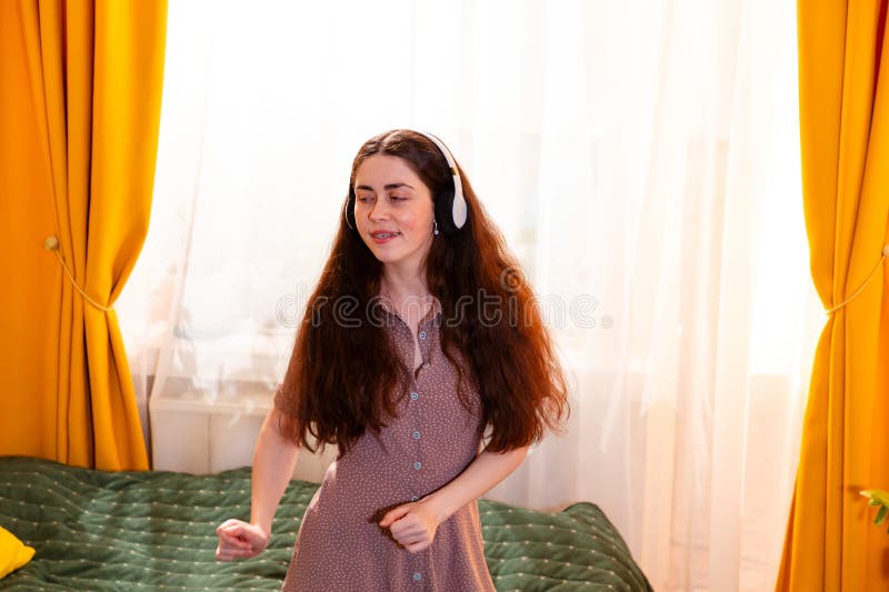 Retrato de una joven feliz con cordones bailando en la cama y disfrutando de su lista de reproducción imagen de archivo libre de regalías