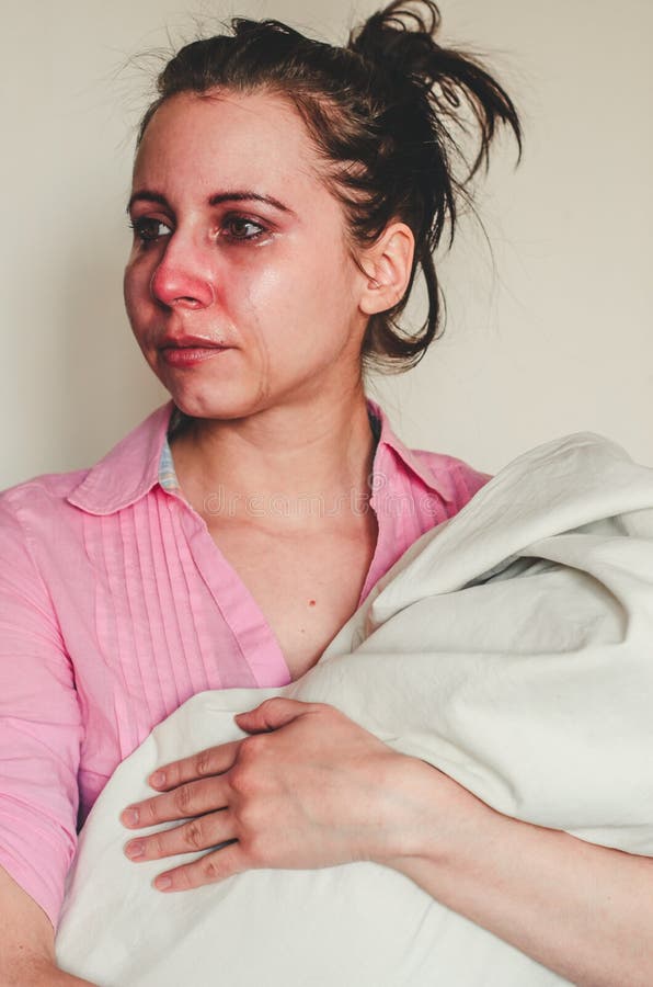 Retrato de una joven madre llorando sosteniendo a su bebé de fondo blanco Concepto de depresión posparto fotos de archivo