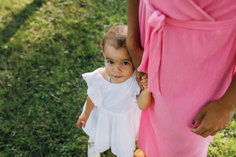 Retrato de una linda niña parada con su madre imagen de archivo