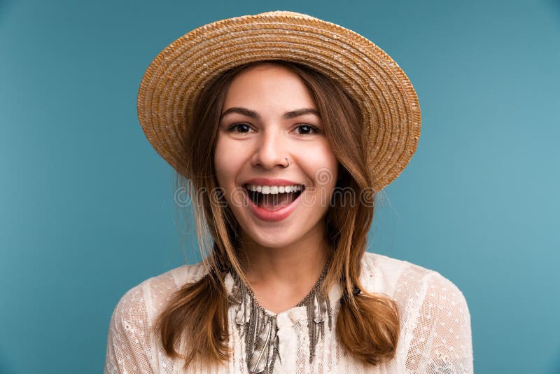 Retrato de una muchacha alegre joven en el sombrero del verano aislado sobre fondo azul, imágenes de archivo libres de regalías Retrato de una muchacha alegre joven en el sombrero del verano aislado sobre fondo azul, imágenes de archivo libres de regalías