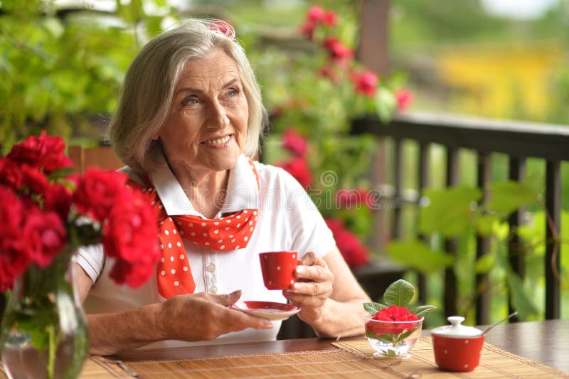 Portrait of a happy aged woman drinking coffee at home. High quality photo. Portrait of a happy aged woman drinking coffee at home. High quality photo